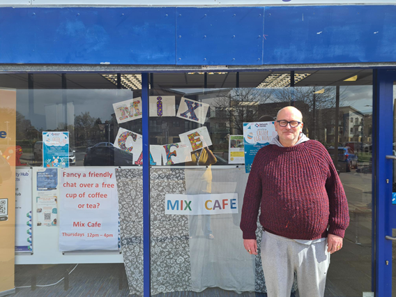 Michael at the Sele Farm community hub which is decorated with Mix Cafe posters