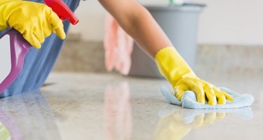 CLose up photograph of someone cleaning a worksurface