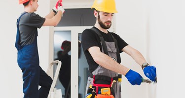 Photograph showing two workmen carrying out work in a home